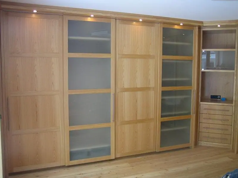 Schrankwand mit Schiebetüren aus Holz und Mattglas und einem Regalelement an der Seite