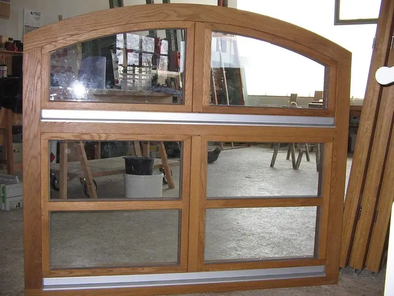 Holzfenster mit Rundbogen und Sprossen, in der Werkstatt aufgenommen