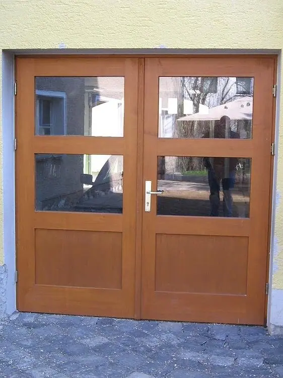 Zweiflügelige Holztür mit Glasfeldern in einer Hauswand